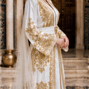 Gold Embroidered Takchita Bridal Caftan Moroccan Wedding Gown Traditional Two Piece Design Beadwork Embellished Kaftan Sleeveless Dress V Neckline Detail Satin Lined Duster Layer Elegant Bridal Ceremony Dress Formal Wedding Attire Cultural